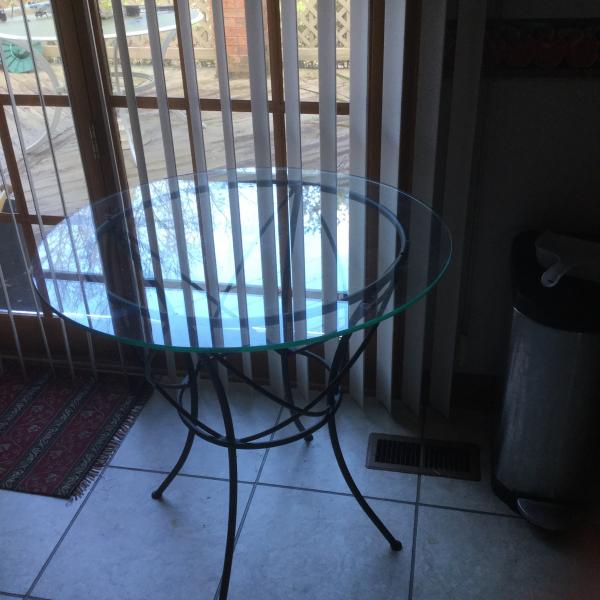 Photo of Brand new outdoor glass top table with wrought iron base and legs 