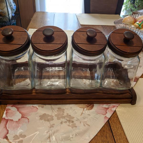 Photo of 4 Glass canisters with wooden lids and base