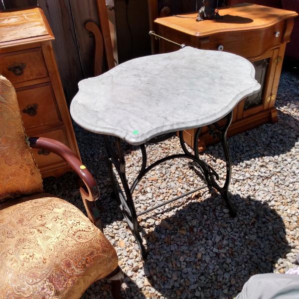 Photo of Antique Singer sewing machine stand with a marble top