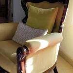 Upholstered wooden accent chair with decorative pillows