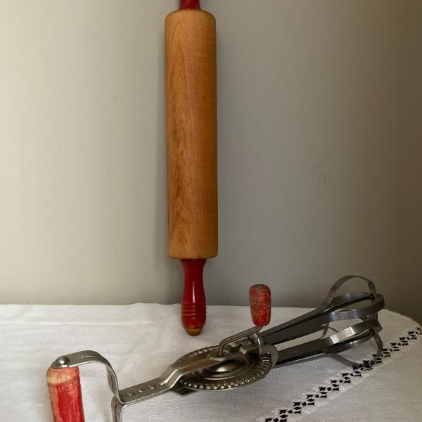 Photo of 2 items: ANDROCK hand mixer/egg beater and unmarked rolling pin red handles