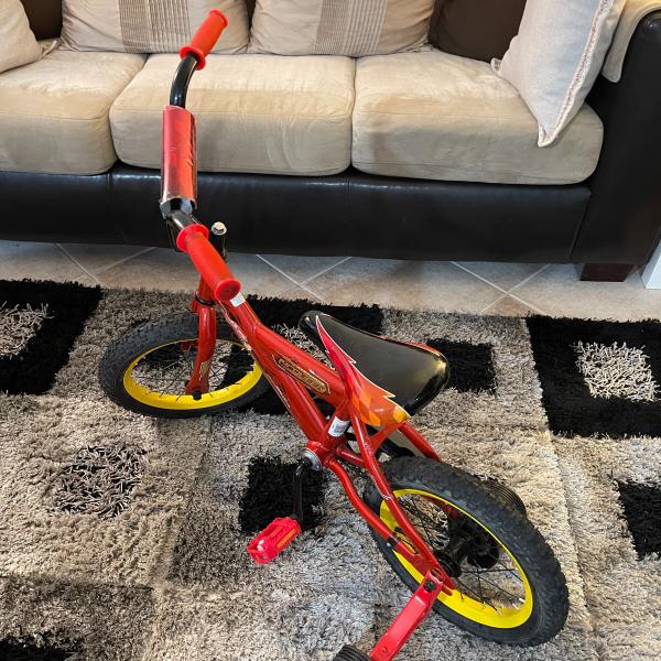 Photo of Huffy Lightning McQueen bicycle with training wheels.