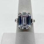 LOT 73: Melania Emerald & Baguette Cut Simulated Diamond Silvertone Ring - Size 