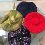 Knit berets some with pom poms