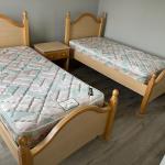 Two, twin beds with mattresses and bedside table