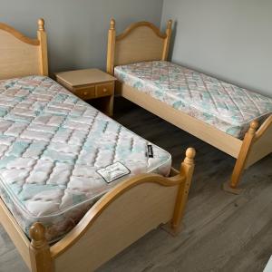 Photo of Two, twin beds with mattresses and bedside table