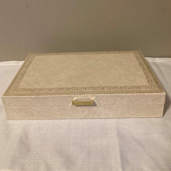 Photo of MELE ivory off white color gold accent, blue inside jewelry box   