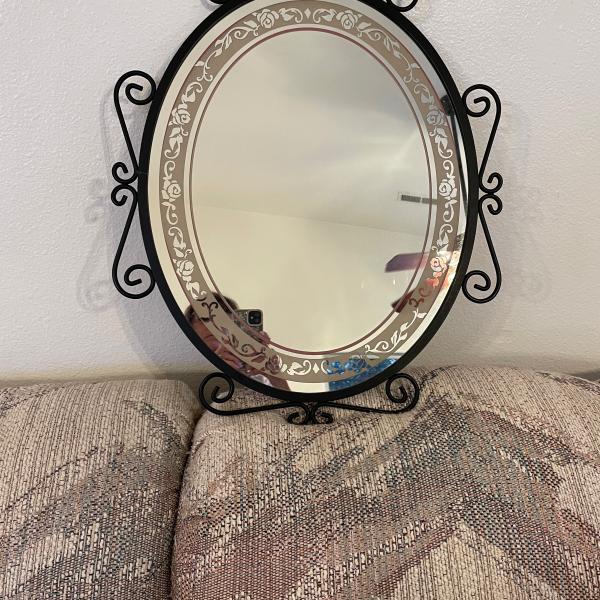 Photo of A mirror with black rod iron. 