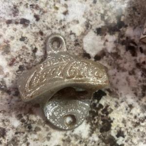 Photo of Vintage Coke bottle opener with original screws.