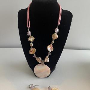 Photo of Pink shell necklace with pink silk cord and matching earrings. 11” long.