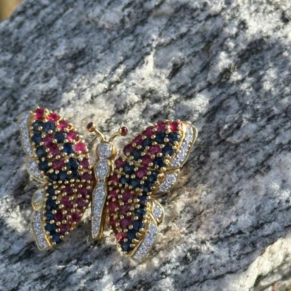 Photo of 18 kt. gold, diamond, ruby, and sapphire butterfly brooch.