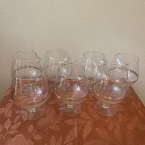 Photo of 7 vintage large brandy snifters with gold trim and spouts.
