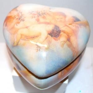 Photo of Cherub-Styled Figurines on a Heart Shaped Covered Jewelry Box with a Lined Pillo