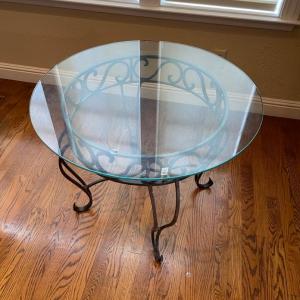 Photo of Glass top table with scrollwork iron base