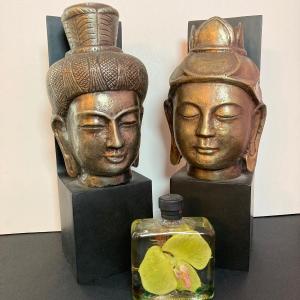 Photo of LOT 135: Bombay Company Bronze Buddha Head Statues and Decorative Bottled Flower