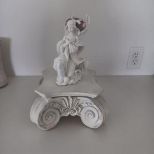 Photo of WHIMSICAL ANGEL RESTING ON AN ORNATE STAND