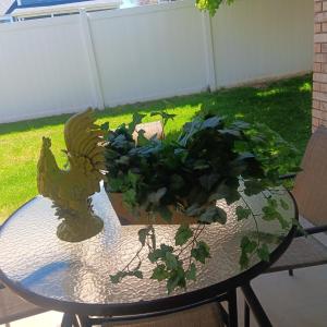 Photo of A LARGE CERAMIC ROOSTER AND A FAUX PLANT IN A BURLAP WRAPPED CONTAINER