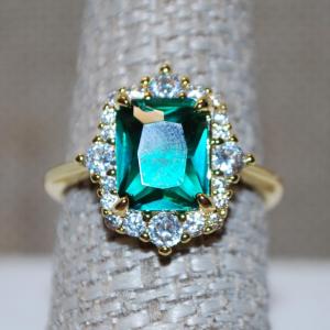 Photo of Size 8 Green Shimmer Cushion Cut Stone Ring with Clear Stone Surrounds on a Gold