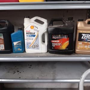 Photo of Partially full & mostly full automotive lubricants and a gas container