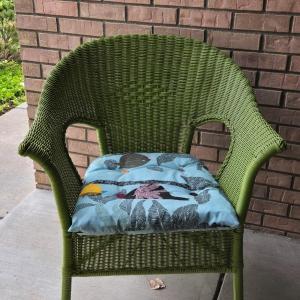 Photo of Green Wicker Style Chair with MulticoloredBird Cushion