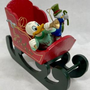 Photo of Disney characters Donald Duck ornaments with wood sleigh