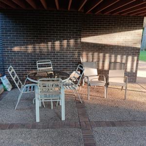 Photo of ROUND GLASS TOP PATIO TABLE WITH 4 CHAIRS AND 2 ADDITIONAL STACKING CHAIRS