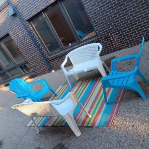 Photo of 2 PLASTIC BENCHES AND 2 ADIRONDACK CHAIRS PLUS AN OUTDOOR RUG