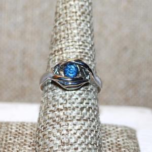 Photo of Size 8¼ Pretty Small Round Blue Stone Ring Nestled in a Silver Tone Wrap-Around